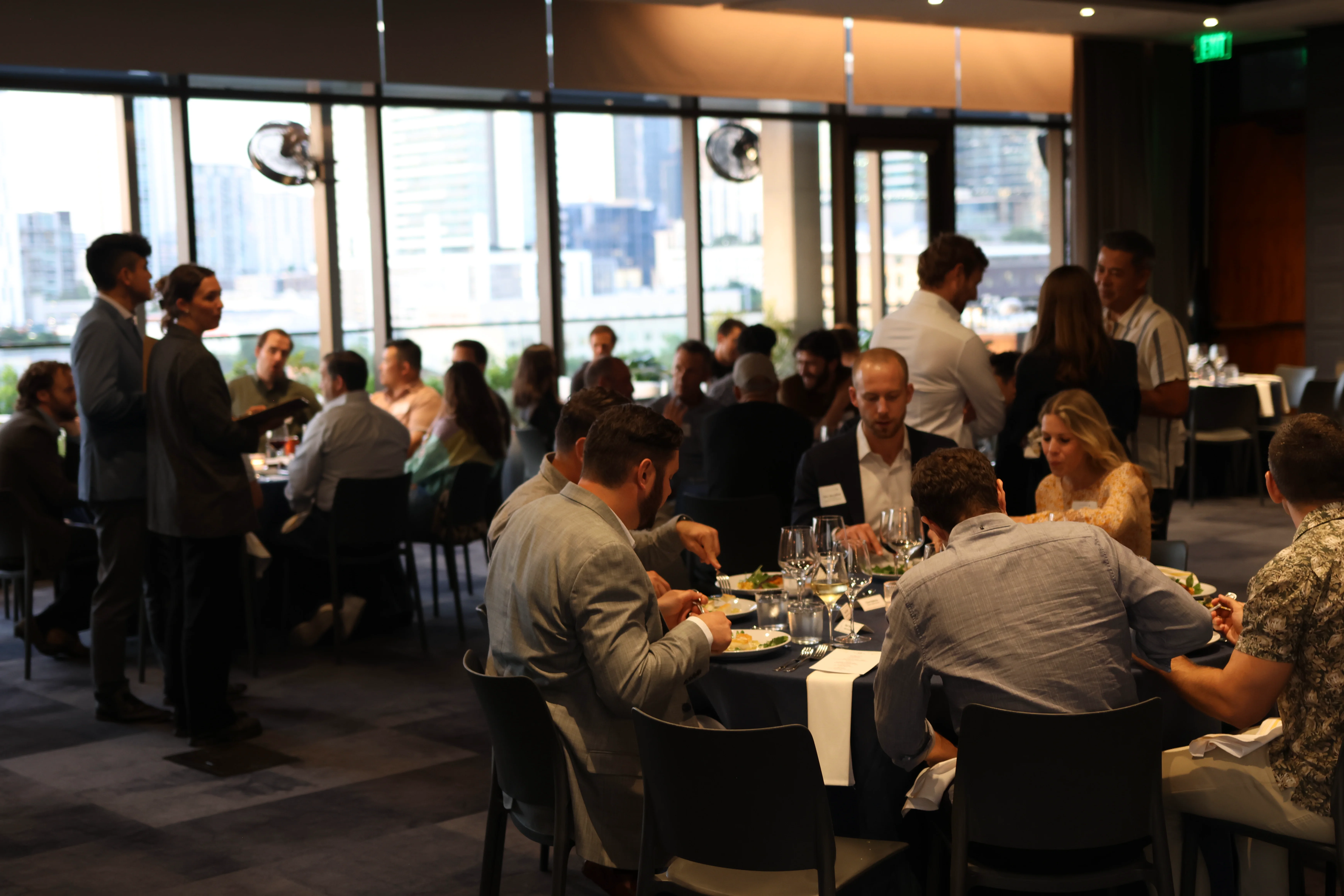 Corporate dinner reception, guests mingling in a downtown Austin venue